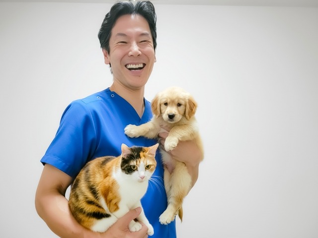 子犬と猫を抱っこしている獣医師
